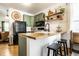 Kitchen with sage colored cabinets, butcher block counters, floating shelves, stainless appliances, and counter seating at 2306 Alabama St, Indianapolis, IN 46205
