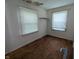 Empty bedroom featuring hardwood floors, a window with blinds, and built-in shelving at 2315 E 3Rd St, Anderson, IN 46012