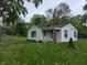 Quaint single-story home featuring white siding, a brick chimney, and a small front porch at 2315 E 3Rd St, Anderson, IN 46012