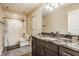 Elegant bathroom featuring a granite countertop, dark wood cabinets, and shower-tub combo at 2377 Finchley Rd, Carmel, IN 46032