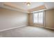 Empty bedroom featuring a tray ceiling, neutral carpeting, and a window with blinds at 2377 Finchley Rd, Carmel, IN 46032