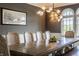 Bright dining room featuring a large wooden table, neutral chairs, elegant lighting, and large windows at 2377 Finchley Rd, Carmel, IN 46032