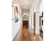 Long hallway featuring archways, wood flooring, modern wall lighting, and recessed display shelving at 2377 Finchley Rd, Carmel, IN 46032