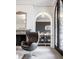 Elegant living room with a decorative fireplace, comfortable chair, and an arched doorway leading to the dining room at 2377 Finchley Rd, Carmel, IN 46032