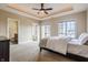 Spacious main bedroom with tray ceiling, ceiling fan, plush carpet and access to ensuite at 2377 Finchley Rd, Carmel, IN 46032