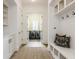 Bright mudroom features built-in bench with storage, coat hooks, and easy access to laundry room with dual washer/dryer at 2377 Finchley Rd, Carmel, IN 46032