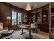 Comfortable office with custom built-ins and trim, an oval desk, and a window overlooking the front yard at 2377 Finchley Rd, Carmel, IN 46032