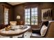 Warm, inviting office with abundant natural light from the large window and dark stained custom wood trim and built-ins at 2377 Finchley Rd, Carmel, IN 46032
