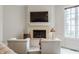 Cozy sitting area with stone fireplace, plush seating, and large window with backyard views at 2377 Finchley Rd, Carmel, IN 46032