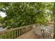 An outdoor wooden deck with a table and chairs, surrounded by lush green trees at 3131 Stillmeadow Dr, Indianapolis, IN 46214