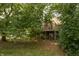 View of the backyard with a deck, stone fireplace and a lush green surround at 3131 Stillmeadow Dr, Indianapolis, IN 46214