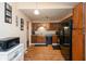 A well-lit kitchen featuring laminate floors, wooden cabinets, black appliances, and a tiled backsplash at 3131 Stillmeadow Dr, Indianapolis, IN 46214