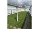 Backyard featuring a white picket fence, a sidewalk, and healthy green grass at 318 Elva St, Anderson, IN 46013