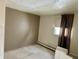 Bedroom featuring neutral walls, carpeting, and a window with curtains and baseboard heater at 318 Elva St, Anderson, IN 46013