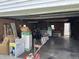Open garage filled with household items including boxes and ladders, featuring a dark-stained concrete floor at 318 Elva St, Anderson, IN 46013