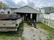 Exterior view of a white detached garage with an open door, a pickup truck, and a motorcycle at 318 Elva St, Anderson, IN 46013