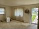Bright living room featuring carpet, windows with sheer curtains, and entry doorway at 318 Elva St, Anderson, IN 46013