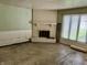 Living room featuring a brick fireplace, wainscoting, and large windows offering natural light at 318 Elva St, Anderson, IN 46013