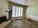Living room with a brick fireplace, large windows, and a door leading outside at 318 Elva St, Anderson, IN 46013