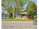 Cozy one-story house featuring a brick foundation and a welcoming front porch with mature trees at 3547 N Emerson Ave, Indianapolis, IN 46218