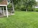 Expansive backyard with grill, green grass, and mature trees providing ample space for outdoor recreation at 3720 E Southern Ave, Indianapolis, IN 46203