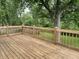 Outdoor wooden deck with railings overlooks lush green yard and mature trees, perfect for outdoor relaxing at 3720 E Southern Ave, Indianapolis, IN 46203