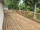 Outdoor wooden deck with railings overlooks lush green yard and mature trees, perfect for outdoor relaxing at 3720 E Southern Ave, Indianapolis, IN 46203