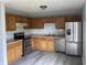 The kitchen has stainless steel appliances, a double sink, and beautiful wood cabinets at 3720 E Southern Ave, Indianapolis, IN 46203