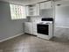 Well-lit kitchen features white cabinets, a black range, stainless sink, and a geometric block glass window at 3720 E Southern Ave, Indianapolis, IN 46203