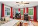 Brightly lit bedroom with hardwood floors, several windows, and a workspace with dual monitors at 4169 Central Ave, Indianapolis, IN 46205