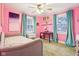 Bright bedroom features pink walls, two windows with blue curtains, desk and ceiling fan at 4169 Central Ave, Indianapolis, IN 46205