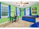 Bedroom painted green features windows, blue curtains, ceiling fan, shelves and bed at 4169 Central Ave, Indianapolis, IN 46205
