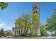 St. Joan of Arc Catholic Church exterior featuring a tall bell tower, stone facade, and manicured landscaping at 4169 Central Ave, Indianapolis, IN 46205