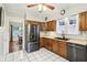 Well-lit kitchen featuring stainless steel refrigerator, tile floors, and wooden cabinets at 4169 Central Ave, Indianapolis, IN 46205