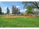 Vibrant outdoor playground featuring swings and climbing equipment surrounded by lush greenery and scattered trees at 4169 Central Ave, Indianapolis, IN 46205