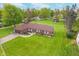 Brick ranch home featuring an attached garage, manicured lawn, garden beds and mature landscaping at 417 W Ash St, Jamestown, IN 46147