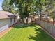 Home's backyard with a small patio, storage shed, fenced in area, and plenty of greenery at 4611 29Th St, Columbus, IN 47203