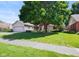 Beautiful home with a lush lawn, mature shade tree, attached garage, and charming red shutters at 4611 29Th St, Columbus, IN 47203