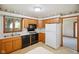 Traditional kitchen featuring wood cabinets, black appliances, and a view into an adjacent room at 4611 29Th St, Columbus, IN 47203