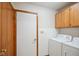 Functional laundry room with wooden cabinets and a white washer and dryer at 4611 29Th St, Columbus, IN 47203