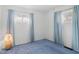 Bright bedroom with soft blue carpet, two windows, and neutral-colored walls at 4864 N Katherine Dr, Indianapolis, IN 46226