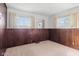 Bedroom showcasing wood-paneled walls, neutral carpet, and two windows for ample natural light at 4864 N Katherine Dr, Indianapolis, IN 46226