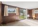 Living room showcasing paneled walls, a sliding glass door, and carpet flooring at 4864 N Katherine Dr, Indianapolis, IN 46226