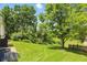 Backyard view showcasing a lush lawn, mature trees, and a private deck area, perfect for outdoor living at 5177 Fairway Dr, Avon, IN 46123