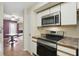 Kitchen with stainless appliances, bright cabinets, and tile backsplash leading to dining room at 5177 Fairway Dr, Avon, IN 46123