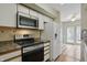 Eat-in kitchen featuring white appliances, a modern microwave, and light-filled breakfast area at 5177 Fairway Dr, Avon, IN 46123