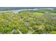 Expansive aerial view of a home surrounded by mature trees, and a shimmering lake in the background at 5190 Potters Pike, Indianapolis, IN 46234