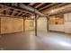 Unfinished basement with exposed wood ceiling, unfinished walls, and a painted concrete floor at 5190 Potters Pike, Indianapolis, IN 46234