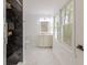 Modern bathroom features marble tile, glass shower, and a bright window offering a natural light source at 5190 Potters Pike, Indianapolis, IN 46234