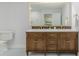 Bathroom with wooden vanity, double sinks, large mirror, and modern fixtures at 5190 Potters Pike, Indianapolis, IN 46234